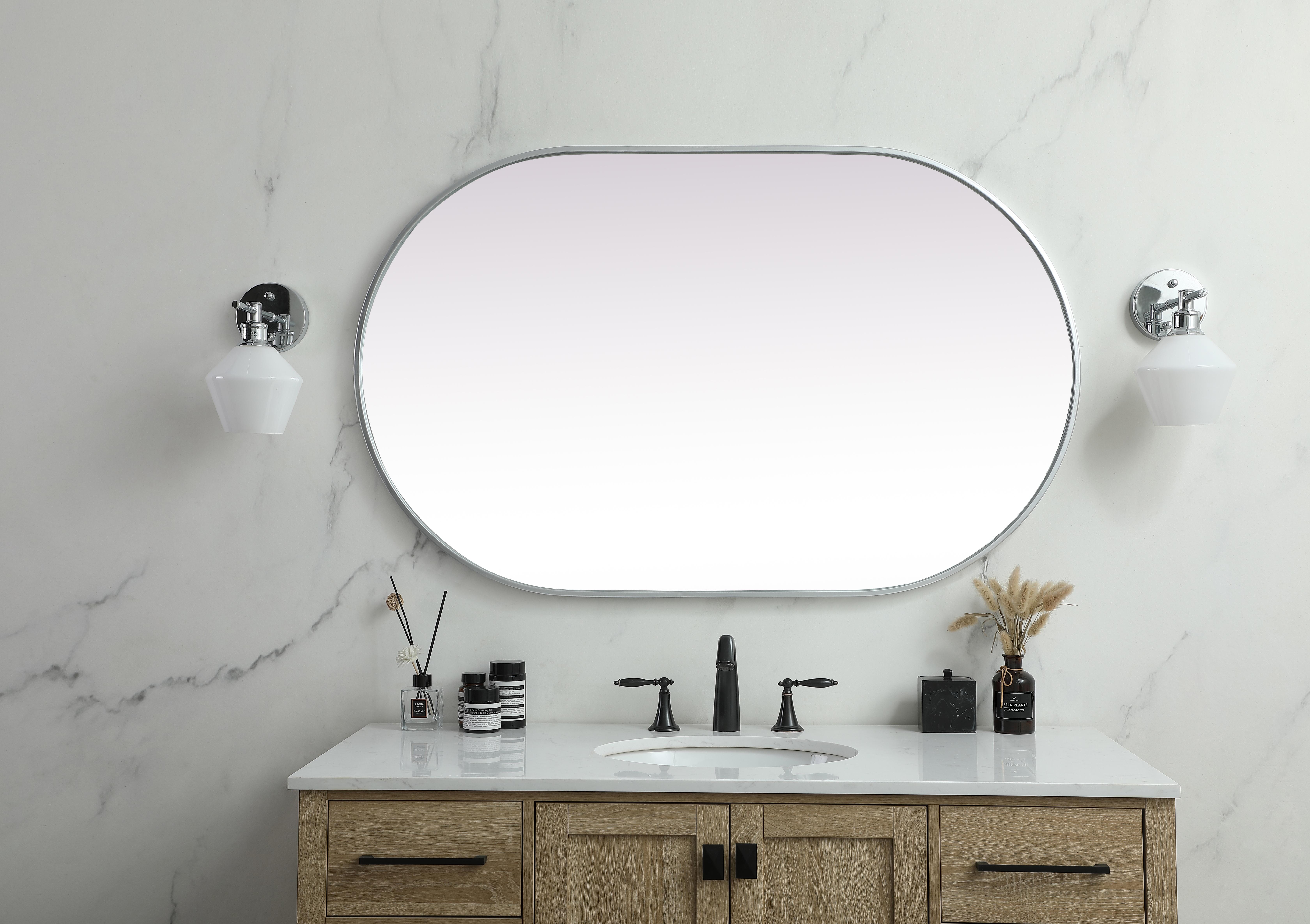 Instantly open up any space in your home with this minimalist wall-mounted mirror. Crafted of metal, this mirror strikes a pill-shaped silhouette. Its slender, clean-lined frame sports a classic finish, while the glass mirror within features a flat, for a brilliant reflection, letting the light bounce off to expand your space. Designed in a pill shape, this metal-frame mirror showcases in the three available satin finishes in black, brass, or silver. Mount this work of art in any room of your choice for added visual impact. Collection: Asha Rooms: living room, entryway, bathroom, office Finish: Silver Width: 1.00" Height: 48.00" Length: 30.00" Weight: 25.00 lb Material: iron and MDF Country of Origin: China Manufacturer Warranty: 1 year limited - alternate view