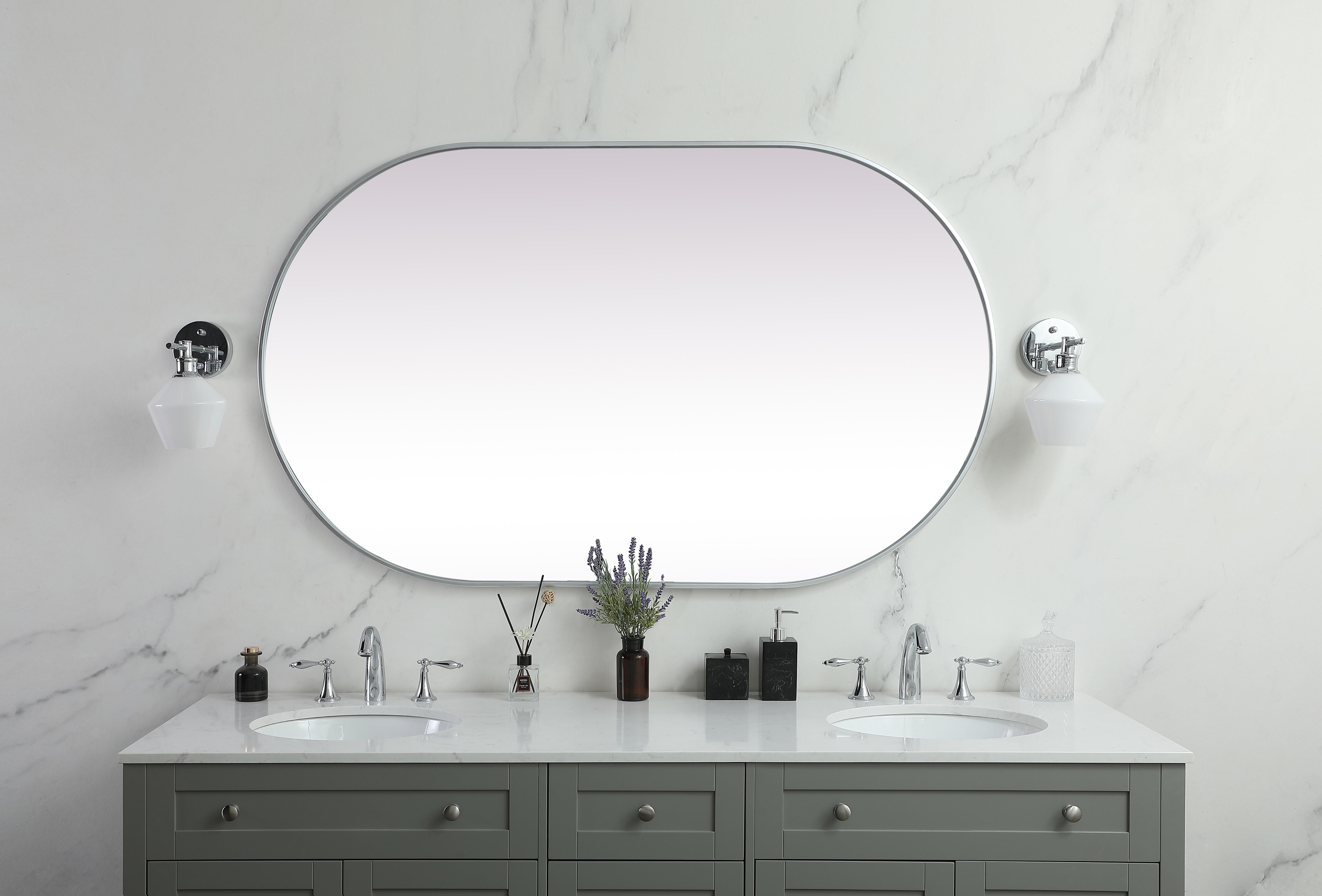 Instantly open up any space in your home with this minimalist wall-mounted mirror. Crafted of metal, this mirror strikes a pill-shaped silhouette. Its slender, clean-lined frame sports a classic finish, while the glass mirror within features a flat, for a brilliant reflection, letting the light bounce off to expand your space. Designed in a pill shape, this metal-frame mirror showcases in the three available satin finishes in black, brass, or silver. Mount this work of art in any room of your choice for added visual impact. Collection: Asha Rooms: living room, entryway, bathroom, office Finish: Silver Width: 1.00" Height: 60.00" Length: 36.00" Weight: 36.00 lb Material: iron and MDF Country of Origin: China Manufacturer Warranty: 1 year limited - alternate view