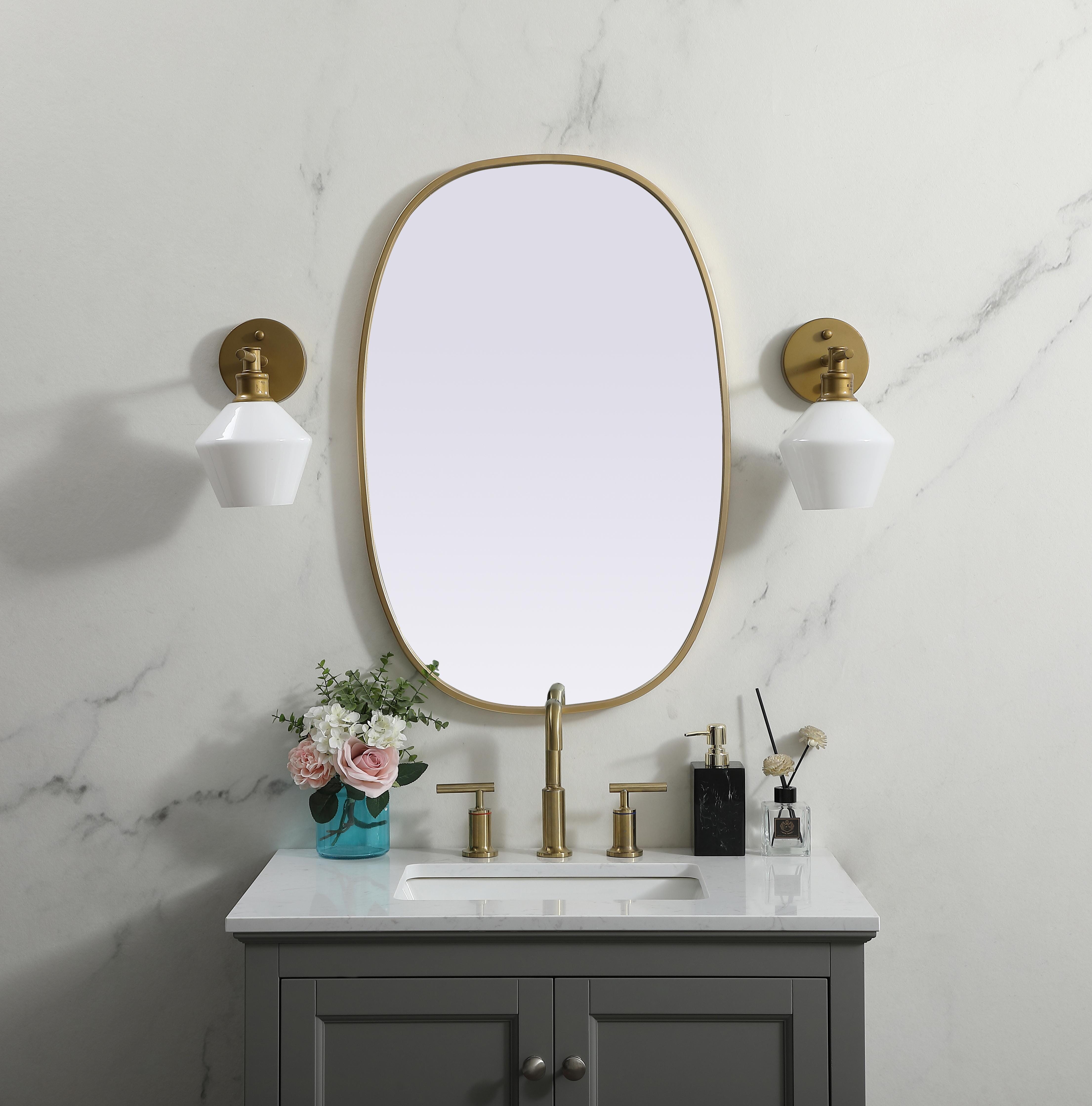 Crafted of metal, this mirror strikes a rounded corner silhouette. Instantly open up any space in your home with this minimalist wall-mounted mirror. Its slender, clean-lined frame sports a classic finish, while the glass mirror within features a flat, for a brilliant reflection, letting the light bounce off to expand your space. Designed in an oblong shape, this metal-frame mirror showcases in the three available satin finishes in black, brass, or silver. Mount this work of art in any room of your choice for added visual impact. Collection: Brynn Finish: Brass Width: 20.00" Height: 30.00" Length: 30.00" Weight: 11.00 lb Material: iron and MDF Country of Origin: China Manufacturer Warranty: 1 year limited - alternate view