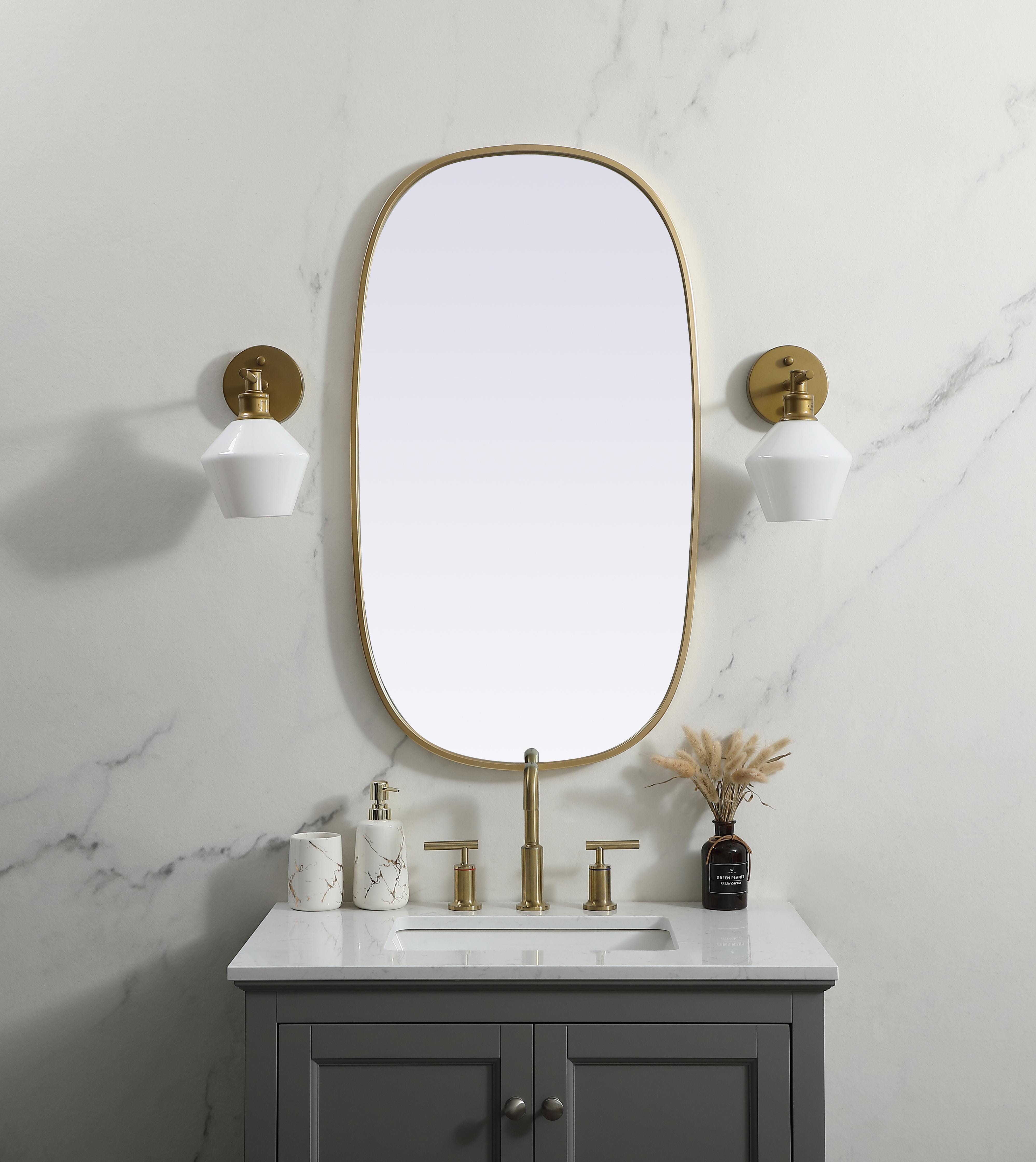 Crafted of metal, this mirror strikes a rounded corner silhouette. Instantly open up any space in your home with this minimalist wall-mounted mirror. Its slender, clean-lined frame sports a classic finish, while the glass mirror within features a flat, for a brilliant reflection, letting the light bounce off to expand your space. Designed in an oblong shape, this metal-frame mirror showcases in the three available satin finishes in black, brass, or silver. Mount this work of art in any room of your choice for added visual impact. Collection: Brynn Finish: Brass Width: 20.00" Height: 36.00" Length: 36.00" Weight: 13.00 lb Material: iron and MDF Country of Origin: China Manufacturer Warranty: 1 year limited - alternate view