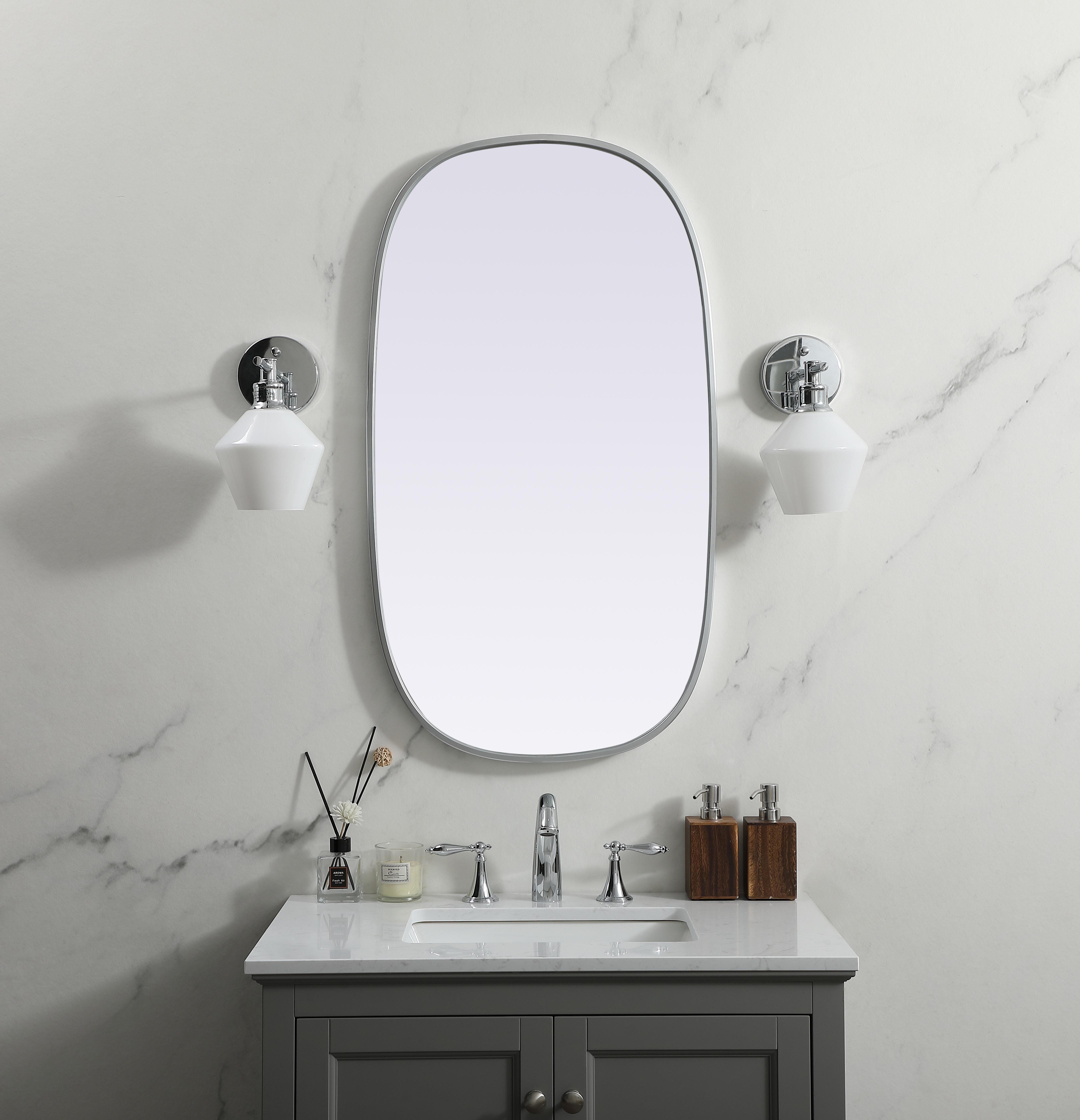 Crafted of metal, this mirror strikes a rounded corner silhouette. Instantly open up any space in your home with this minimalist wall-mounted mirror. Its slender, clean-lined frame sports a classic finish, while the glass mirror within features a flat, for a brilliant reflection, letting the light bounce off to expand your space. Designed in an oblong shape, this metal-frame mirror showcases in the three available satin finishes in black, brass, or silver. Mount this work of art in any room of your choice for added visual impact. Collection: Brynn Finish: Silver Width: 20.00" Height: 36.00" Length: 36.00" Weight: 13.00 lb Material: iron and MDF Country of Origin: China Manufacturer Warranty: 1 year limited - alternate view