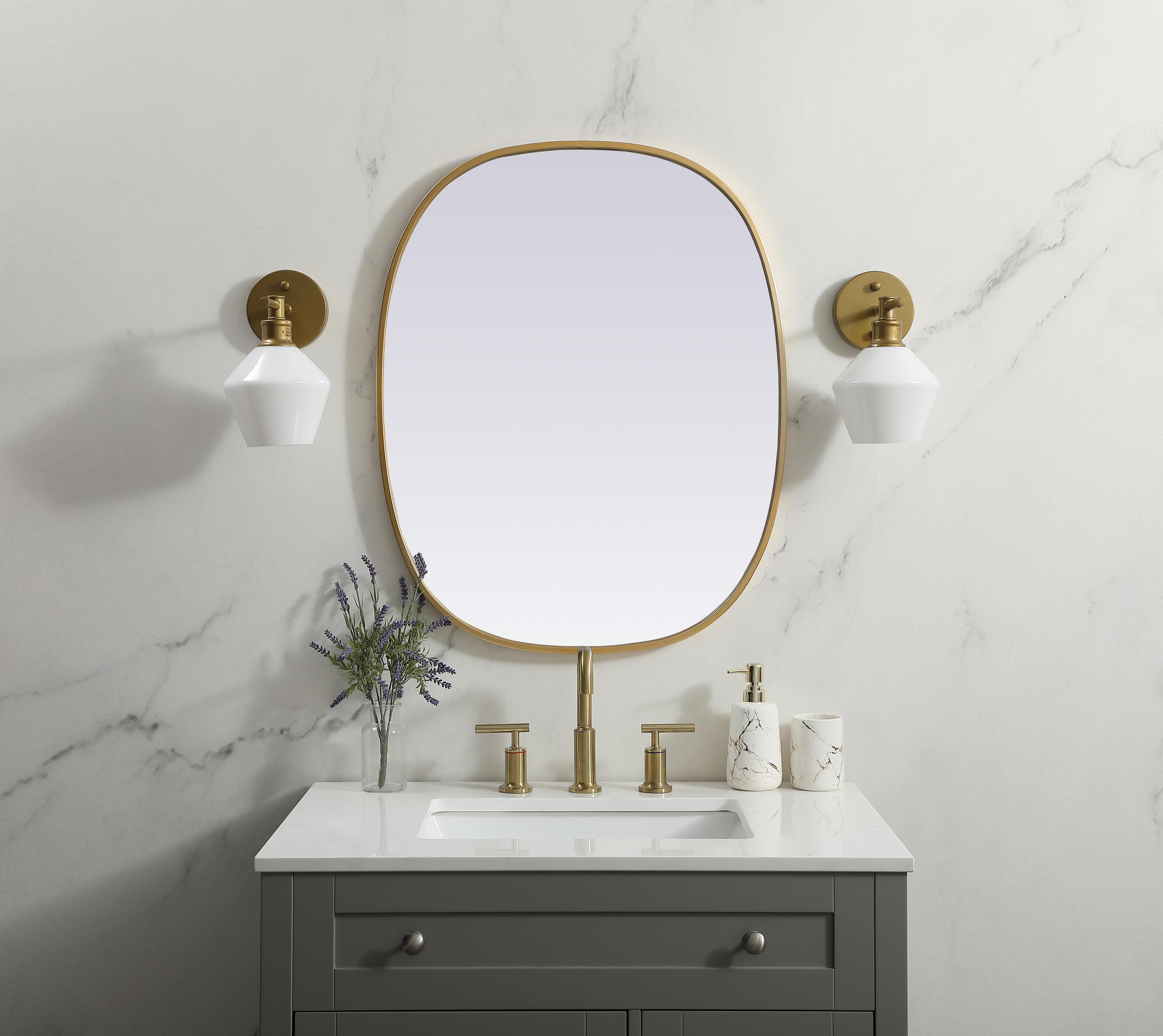 Crafted of metal, this mirror strikes a rounded corner silhouette. Instantly open up any space in your home with this minimalist wall-mounted mirror. Its slender, clean-lined frame sports a classic finish, while the glass mirror within features a flat, for a brilliant reflection, letting the light bounce off to expand your space. Designed in an oblong shape, this metal-frame mirror showcases in the three available satin finishes in black, brass, or silver. Mount this work of art in any room of your choice for added visual impact. Collection: Brynn Finish: Brass Width: 24.00" Height: 30.00" Length: 30.00" Weight: 12.00 lb Material: iron and MDF Country of Origin: China Manufacturer Warranty: 1 year limited - alternate view