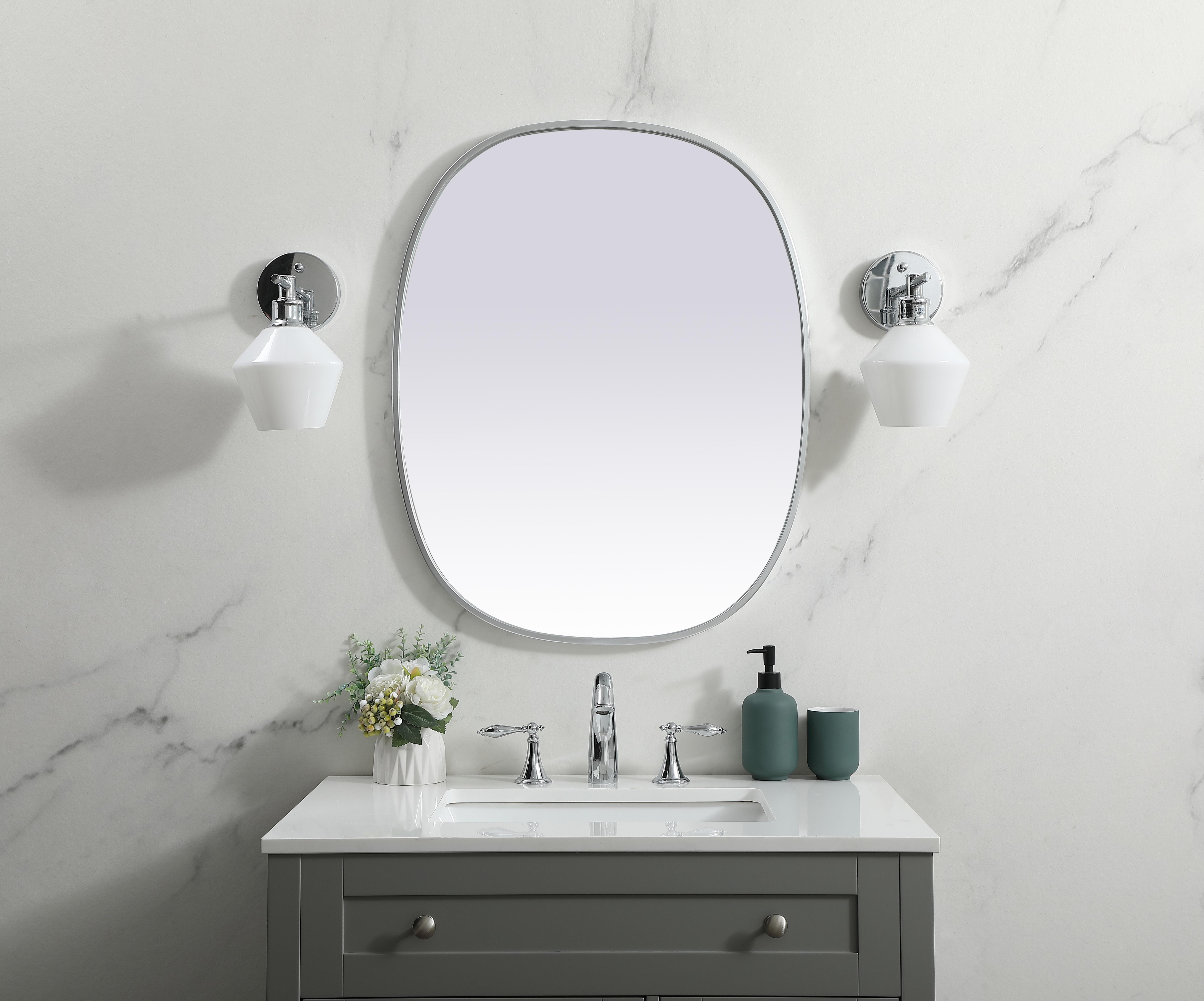 Crafted of metal, this mirror strikes a rounded corner silhouette. Instantly open up any space in your home with this minimalist wall-mounted mirror. Its slender, clean-lined frame sports a classic finish, while the glass mirror within features a flat, for a brilliant reflection, letting the light bounce off to expand your space. Designed in an oblong shape, this metal-frame mirror showcases in the three available satin finishes in black, brass, or silver. Mount this work of art in any room of your choice for added visual impact. Collection: Brynn Finish: Silver Width: 24.00" Height: 30.00" Length: 30.00" Weight: 12.00 lb Material: iron and MDF Country of Origin: China Manufacturer Warranty: 1 year limited - alternate view