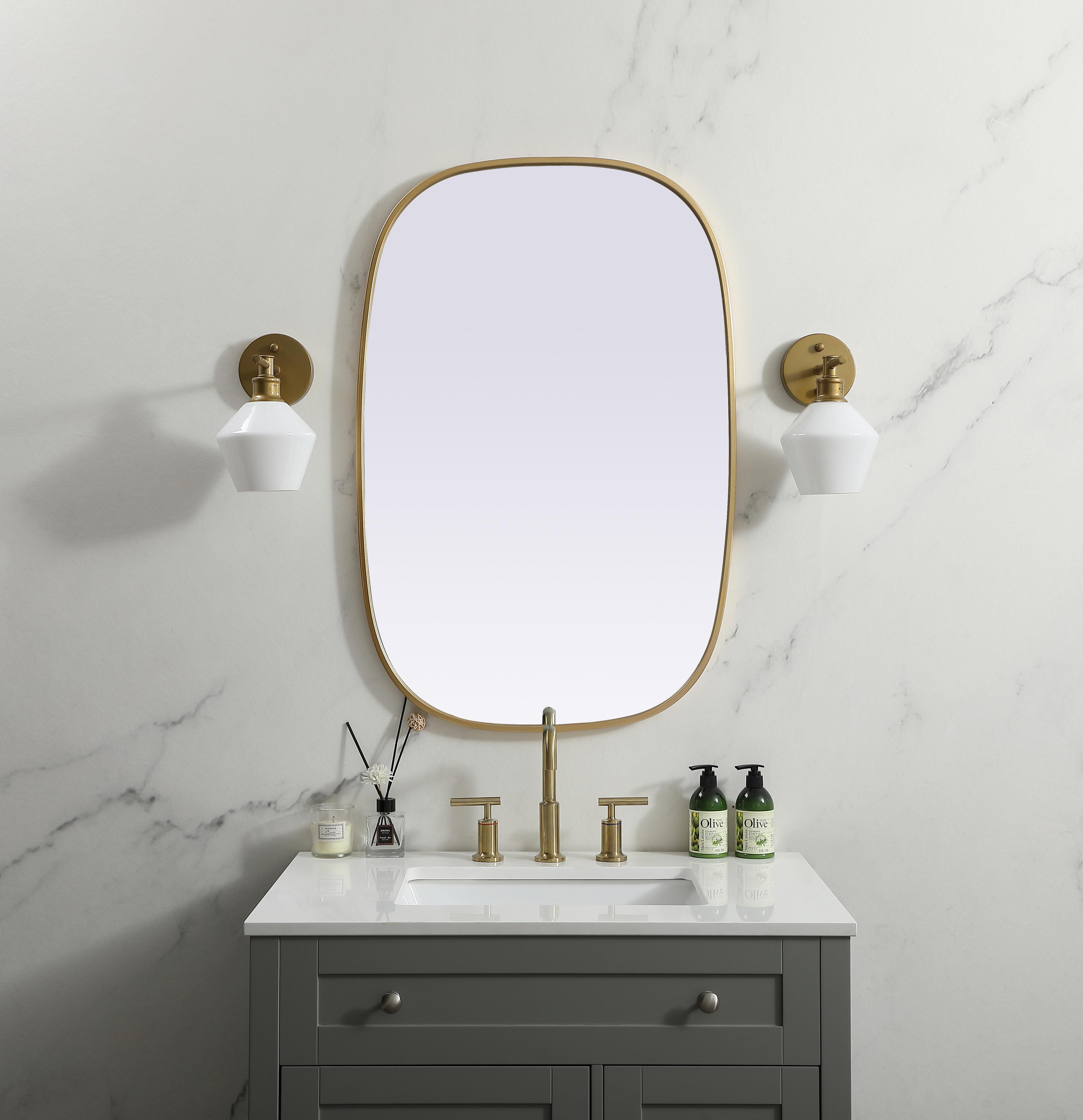 Crafted of metal, this mirror strikes a rounded corner silhouette. Instantly open up any space in your home with this minimalist wall-mounted mirror. Its slender, clean-lined frame sports a classic finish, while the glass mirror within features a flat, for a brilliant reflection, letting the light bounce off to expand your space. Designed in an oblong shape, this metal-frame mirror showcases in the three available satin finishes in black, brass, or silver. Mount this work of art in any room of your choice for added visual impact. Collection: Brynn Finish: Brass Width: 24.00" Height: 36.00" Length: 36.00" Weight: 15.00 lb Material: iron and MDF Country of Origin: China Manufacturer Warranty: 1 year limited - alternate view