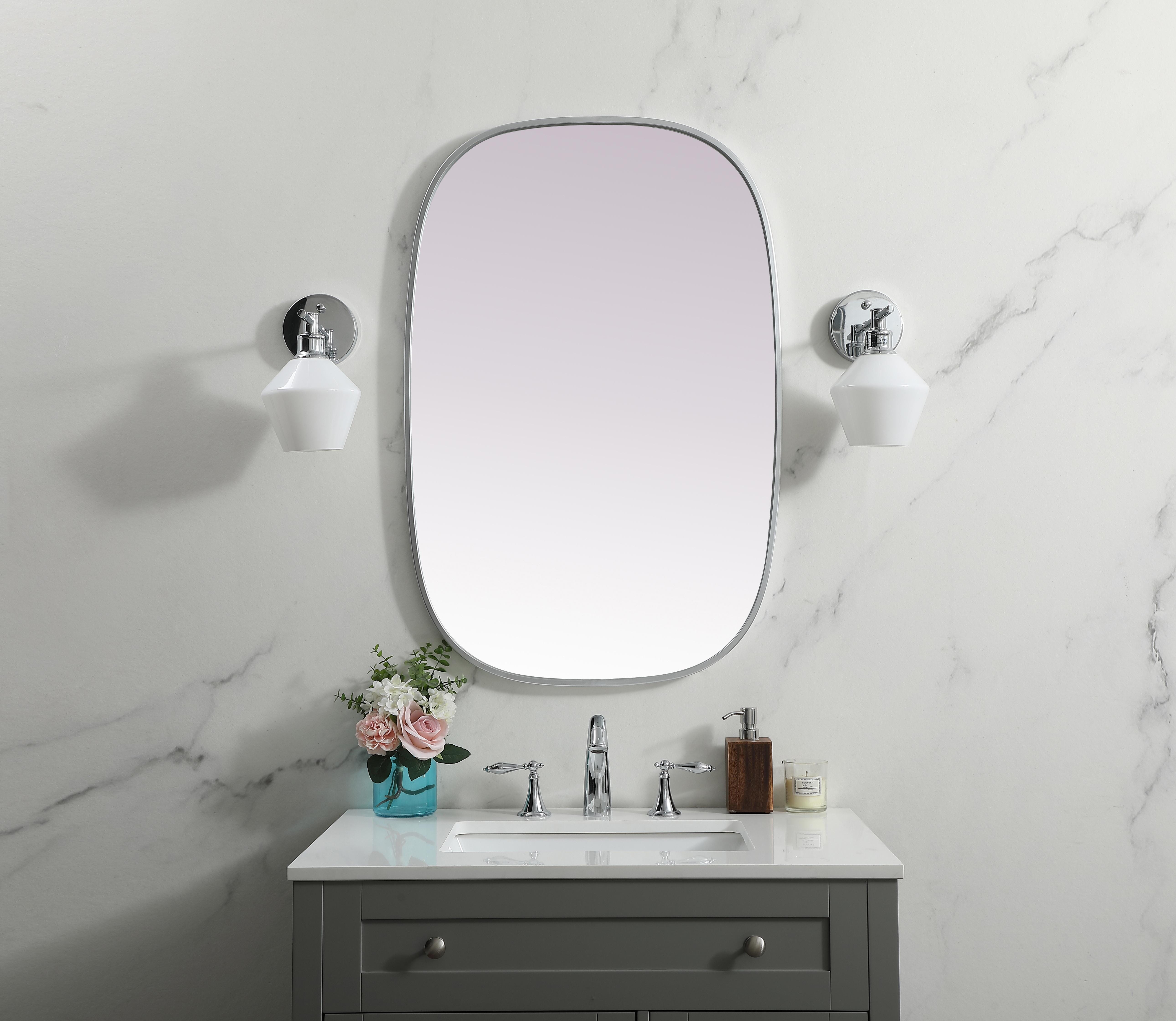 Crafted of metal, this mirror strikes a rounded corner silhouette. Instantly open up any space in your home with this minimalist wall-mounted mirror. Its slender, clean-lined frame sports a classic finish, while the glass mirror within features a flat, for a brilliant reflection, letting the light bounce off to expand your space. Designed in an oblong shape, this metal-frame mirror showcases in the three available satin finishes in black, brass, or silver. Mount this work of art in any room of your choice for added visual impact. Collection: Brynn Finish: Silver Width: 24.00" Height: 36.00" Length: 36.00" Weight: 15.00 lb Material: iron and MDF Country of Origin: China Manufacturer Warranty: 1 year limited - alternate view