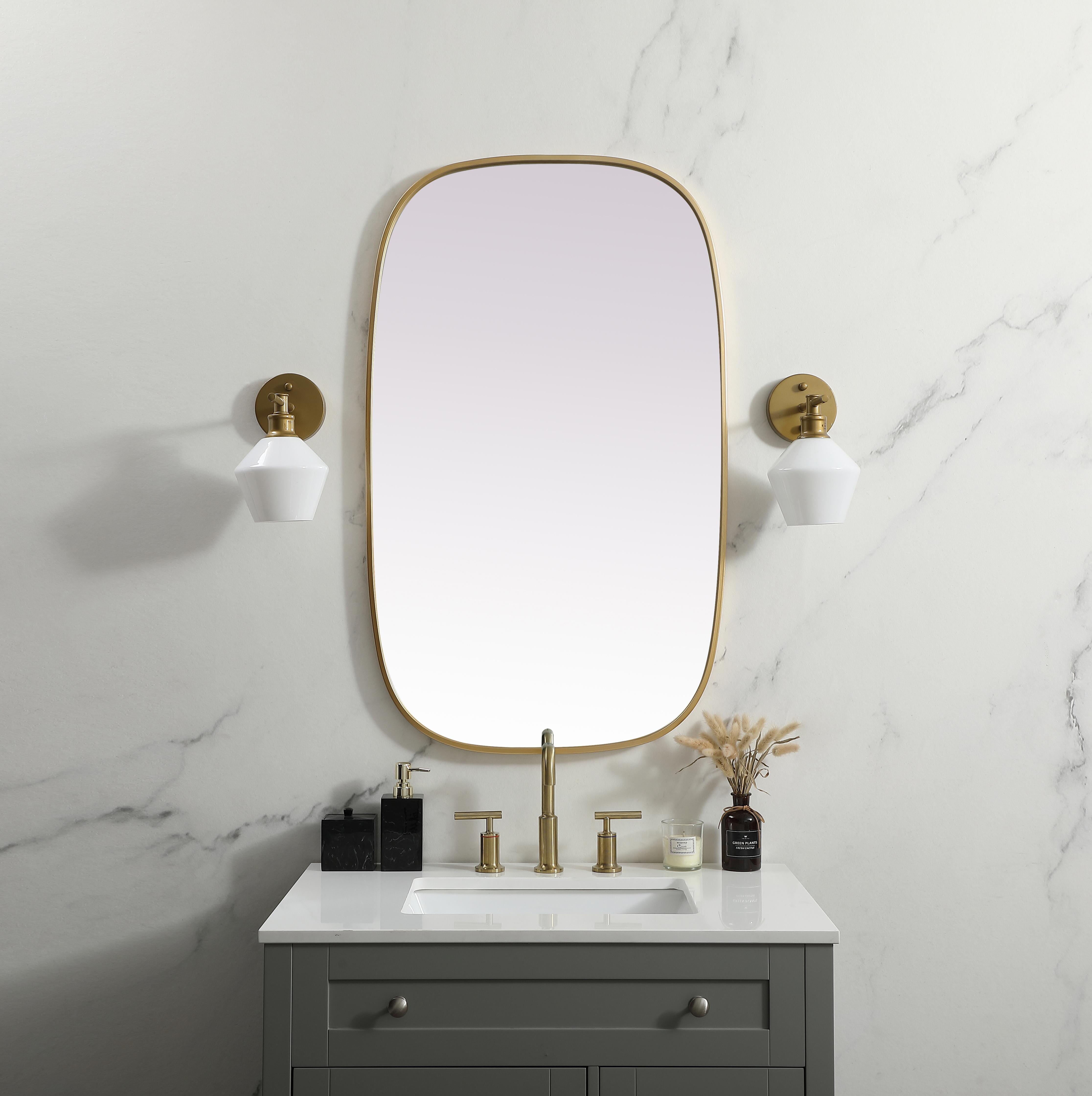 Crafted of metal, this mirror strikes a rounded corner silhouette. Instantly open up any space in your home with this minimalist wall-mounted mirror. Its slender, clean-lined frame sports a classic finish, while the glass mirror within features a flat, for a brilliant reflection, letting the light bounce off to expand your space. Designed in an oblong shape, this metal-frame mirror showcases in the three available satin finishes in black, brass, or silver. Mount this work of art in any room of your choice for added visual impact. Collection: Brynn Finish: Brass Width: 24.00" Height: 40.00" Length: 40.00" Weight: 17.00 lb Material: iron and MDF Country of Origin: China Manufacturer Warranty: 1 year limited - alternate view
