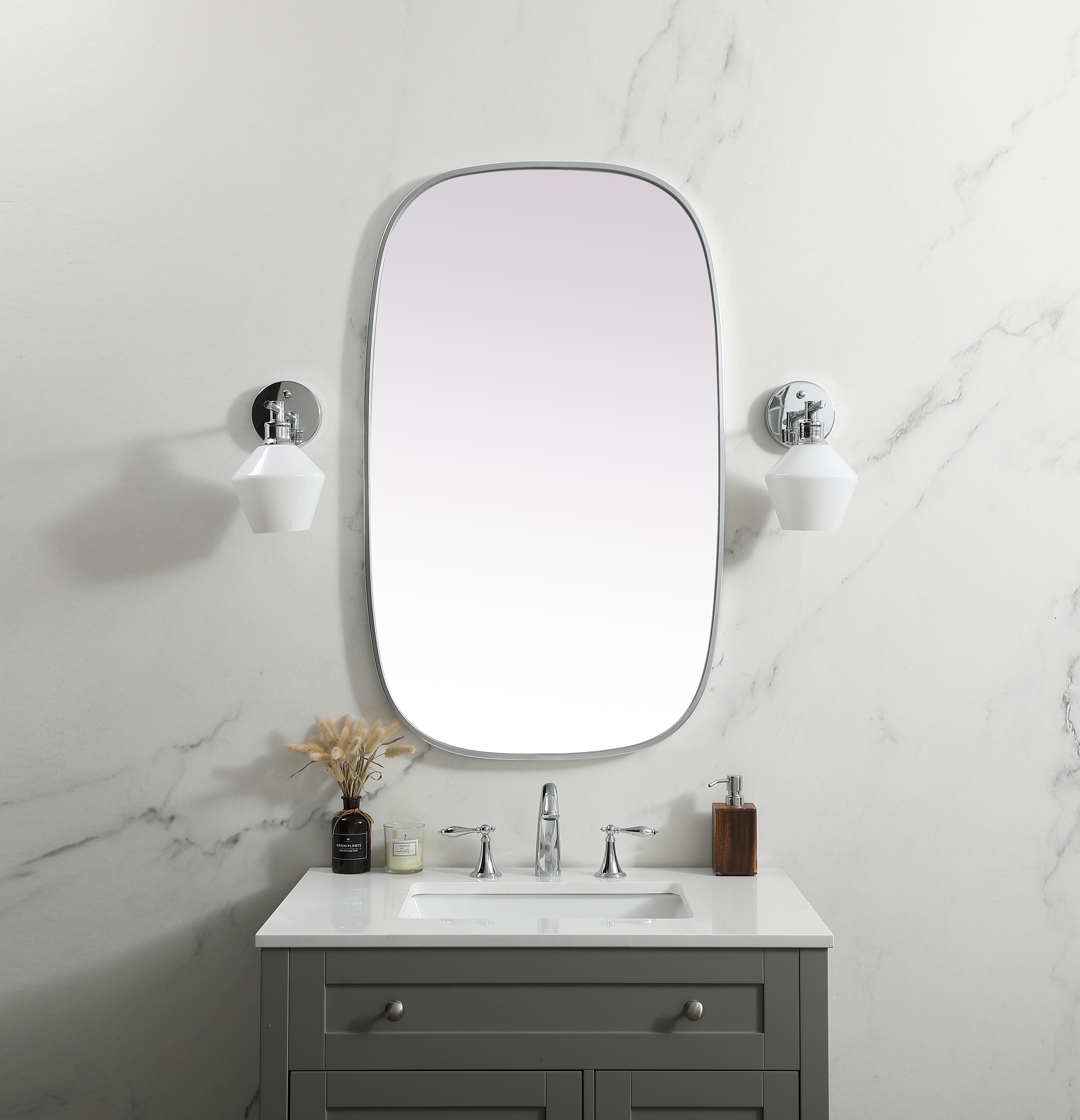 Crafted of metal, this mirror strikes a rounded corner silhouette. Instantly open up any space in your home with this minimalist wall-mounted mirror. Its slender, clean-lined frame sports a classic finish, while the glass mirror within features a flat, for a brilliant reflection, letting the light bounce off to expand your space. Designed in an oblong shape, this metal-frame mirror showcases in the three available satin finishes in black, brass, or silver. Mount this work of art in any room of your choice for added visual impact. Collection: Brynn Finish: Silver Width: 24.00" Height: 40.00" Length: 40.00" Weight: 17.00 lb Material: iron and MDF Country of Origin: China Manufacturer Warranty: 1 year limited - alternate view