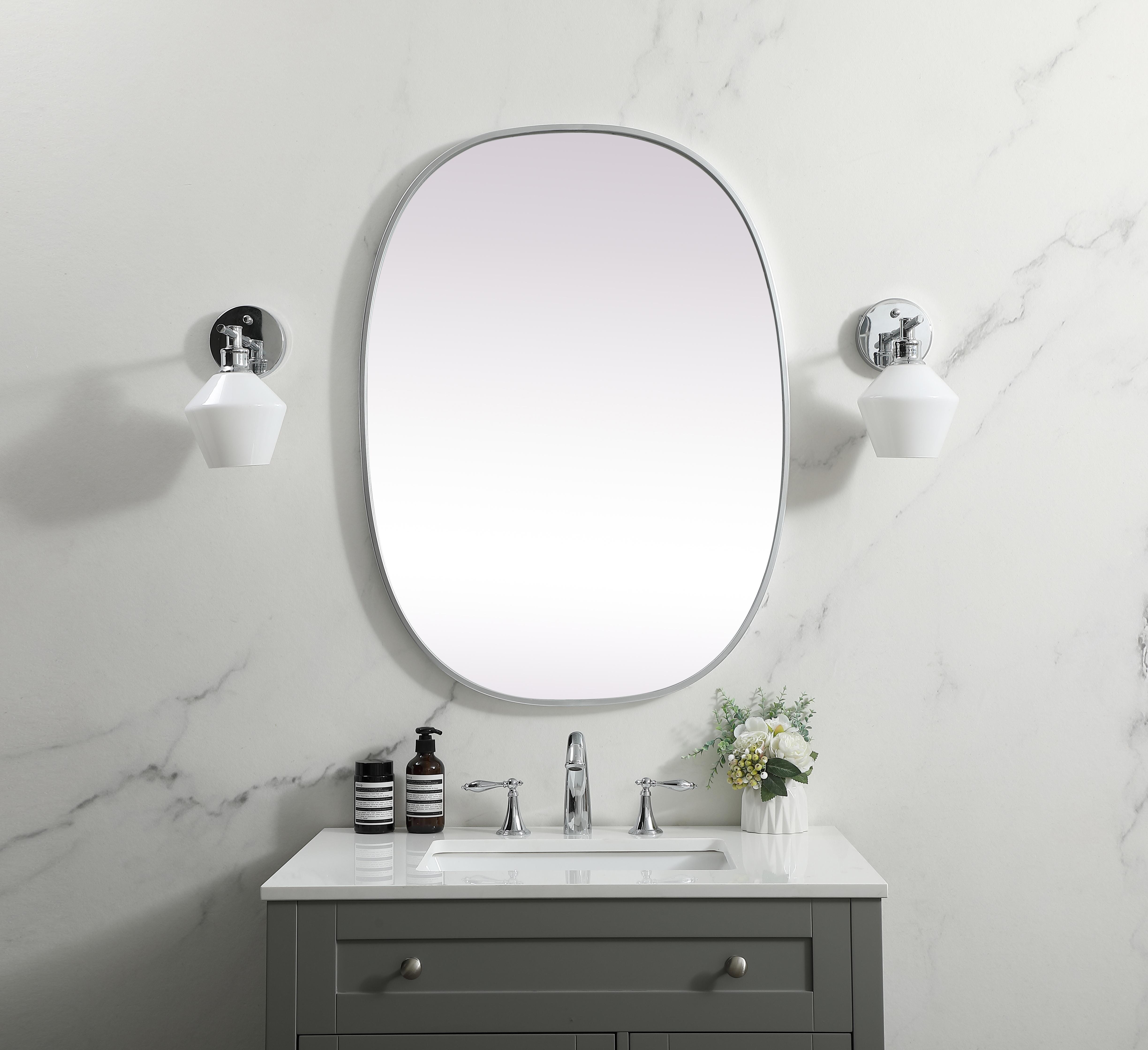 Crafted of metal, this mirror strikes a rounded corner silhouette. Instantly open up any space in your home with this minimalist wall-mounted mirror. Its slender, clean-lined frame sports a classic finish, while the glass mirror within features a flat, for a brilliant reflection, letting the light bounce off to expand your space. Designed in an oblong shape, this metal-frame mirror showcases in the three available satin finishes in black, brass, or silver. Mount this work of art in any room of your choice for added visual impact. Collection: Brynn Finish: Silver Width: 27.00" Height: 36.00" Length: 36.00" Weight: 16.00 lb Material: iron and MDF Country of Origin: China Manufacturer Warranty: 1 year limited - alternate view