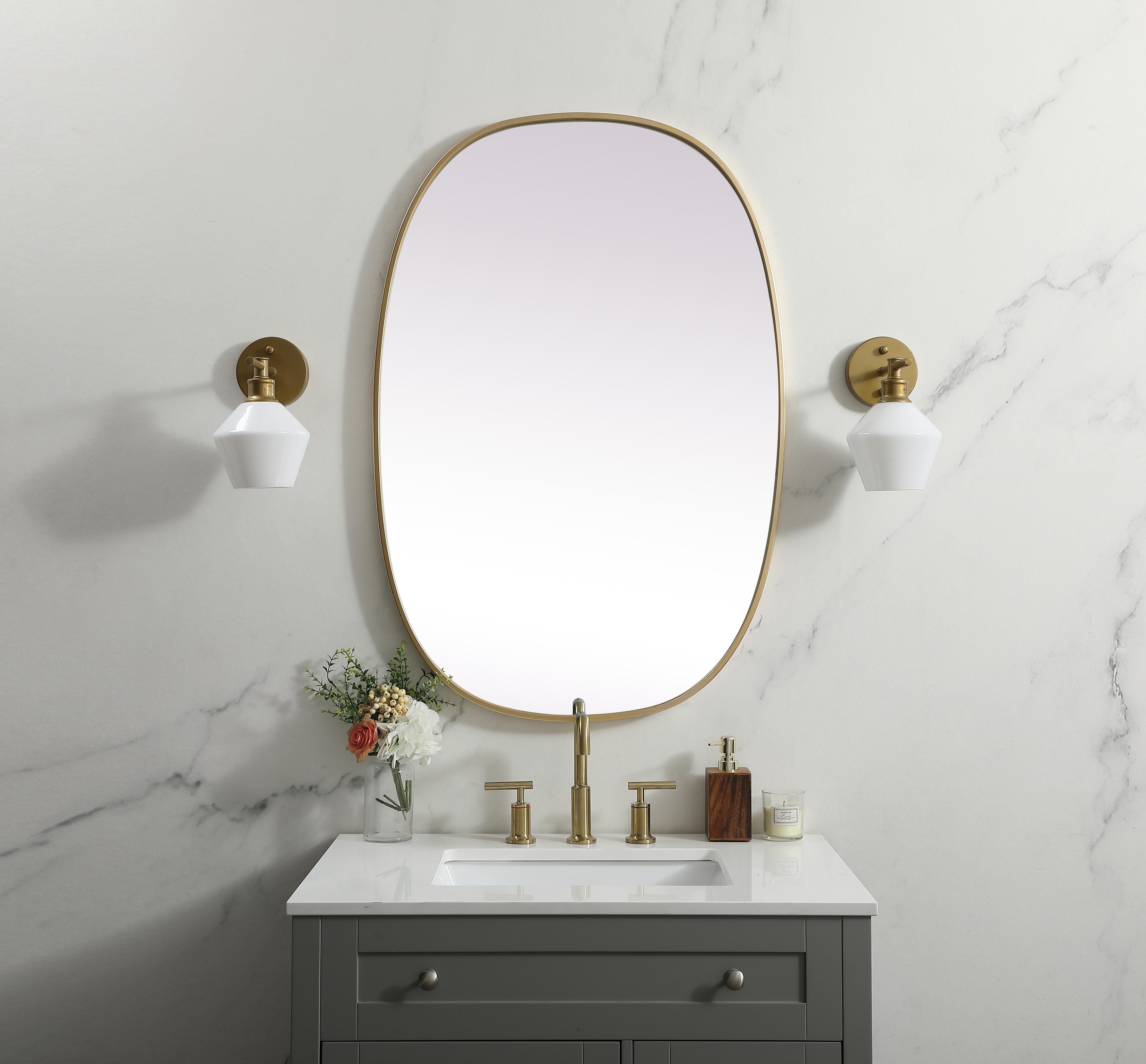 Crafted of metal, this mirror strikes a rounded corner silhouette. Instantly open up any space in your home with this minimalist wall-mounted mirror. Its slender, clean-lined frame sports a classic finish, while the glass mirror within features a flat, for a brilliant reflection, letting the light bounce off to expand your space. Designed in an oblong shape, this metal-frame mirror showcases in the three available satin finishes in black, brass, or silver. Mount this work of art in any room of your choice for added visual impact. Collection: Brynn Finish: Brass Width: 27.00" Height: 40.00" Length: 40.00" Weight: 18.00 lb Material: iron and MDF Country of Origin: China Manufacturer Warranty: 1 year limited - alternate view
