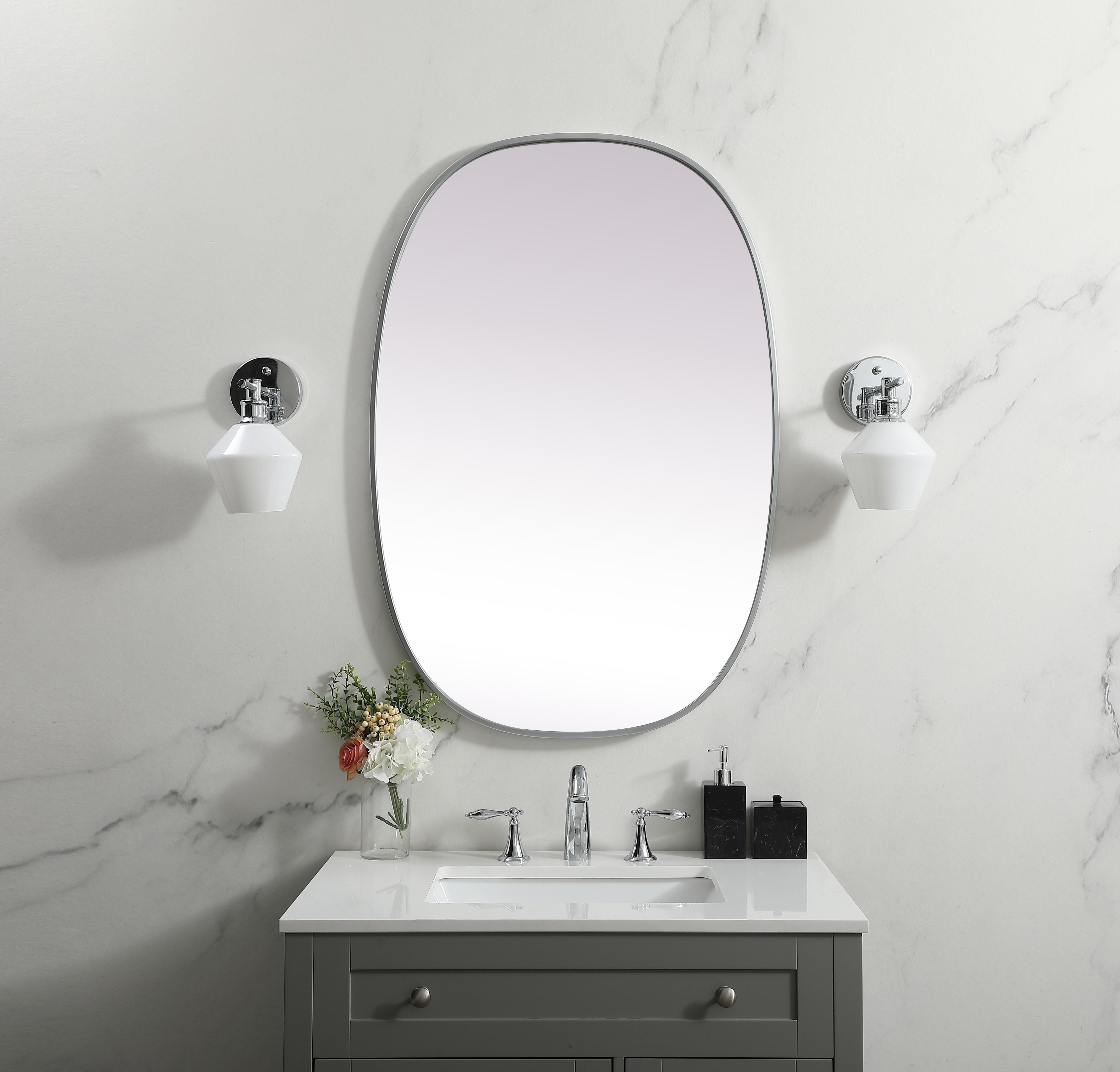 Crafted of metal, this mirror strikes a rounded corner silhouette. Instantly open up any space in your home with this minimalist wall-mounted mirror. Its slender, clean-lined frame sports a classic finish, while the glass mirror within features a flat, for a brilliant reflection, letting the light bounce off to expand your space. Designed in an oblong shape, this metal-frame mirror showcases in the three available satin finishes in black, brass, or silver. Mount this work of art in any room of your choice for added visual impact. Collection: Brynn Finish: Silver Width: 27.00" Height: 40.00" Length: 40.00" Weight: 18.00 lb Material: iron and MDF Country of Origin: China Manufacturer Warranty: 1 year limited - alternate view