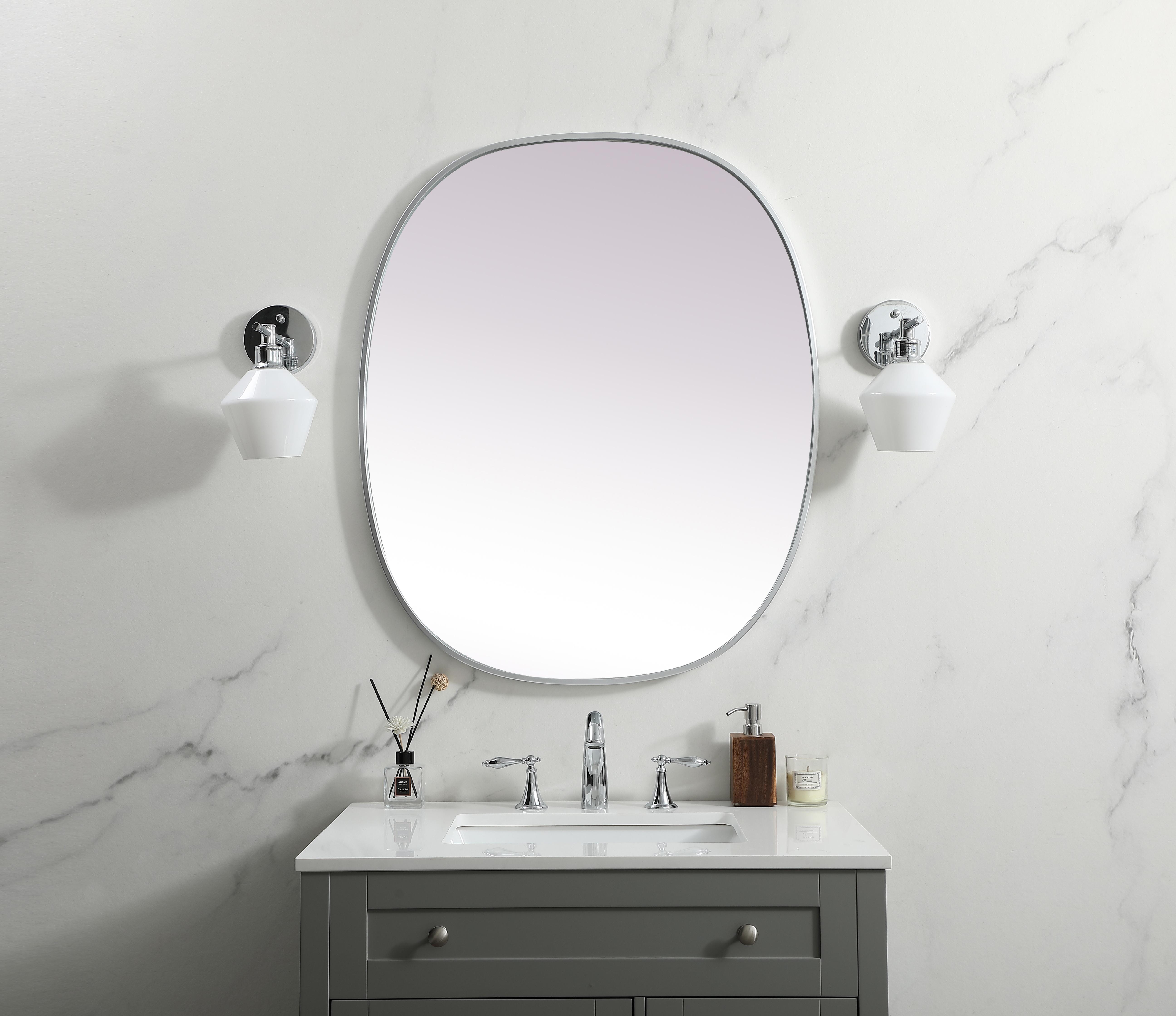 Crafted of metal, this mirror strikes a rounded corner silhouette. Instantly open up any space in your home with this minimalist wall-mounted mirror. Its slender, clean-lined frame sports a classic finish, while the glass mirror within features a flat, for a brilliant reflection, letting the light bounce off to expand your space. Designed in an oblong shape, this metal-frame mirror showcases in the three available satin finishes in black, brass, or silver. Mount this work of art in any room of your choice for added visual impact. Collection: Brynn Finish: Silver Width: 30.00" Height: 36.00" Length: 36.00" Weight: 18.00 lb Material: iron and MDF Country of Origin: China Manufacturer Warranty: 1 year limited - alternate view