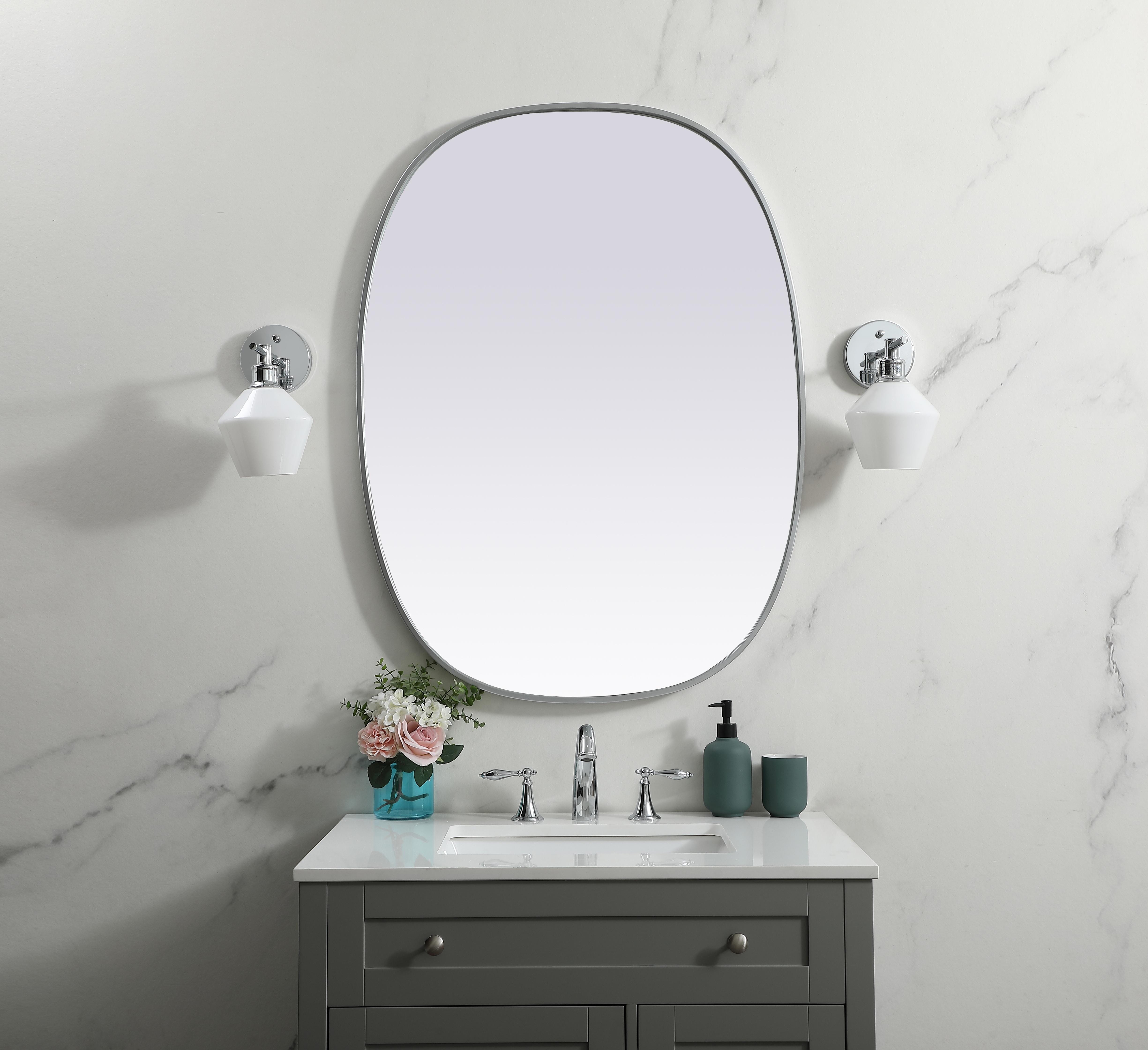 Crafted of metal, this mirror strikes a rounded corner silhouette. Instantly open up any space in your home with this minimalist wall-mounted mirror. Its slender, clean-lined frame sports a classic finish, while the glass mirror within features a flat, for a brilliant reflection, letting the light bounce off to expand your space. Designed in an oblong shape, this metal-frame mirror showcases in the three available satin finishes in black, brass, or silver. Mount this work of art in any room of your choice for added visual impact. Collection: Brynn Finish: Silver Width: 30.00" Height: 40.00" Length: 40.00" Weight: 19.00 lb Material: iron and MDF Country of Origin: China Manufacturer Warranty: 1 year limited - alternate view
