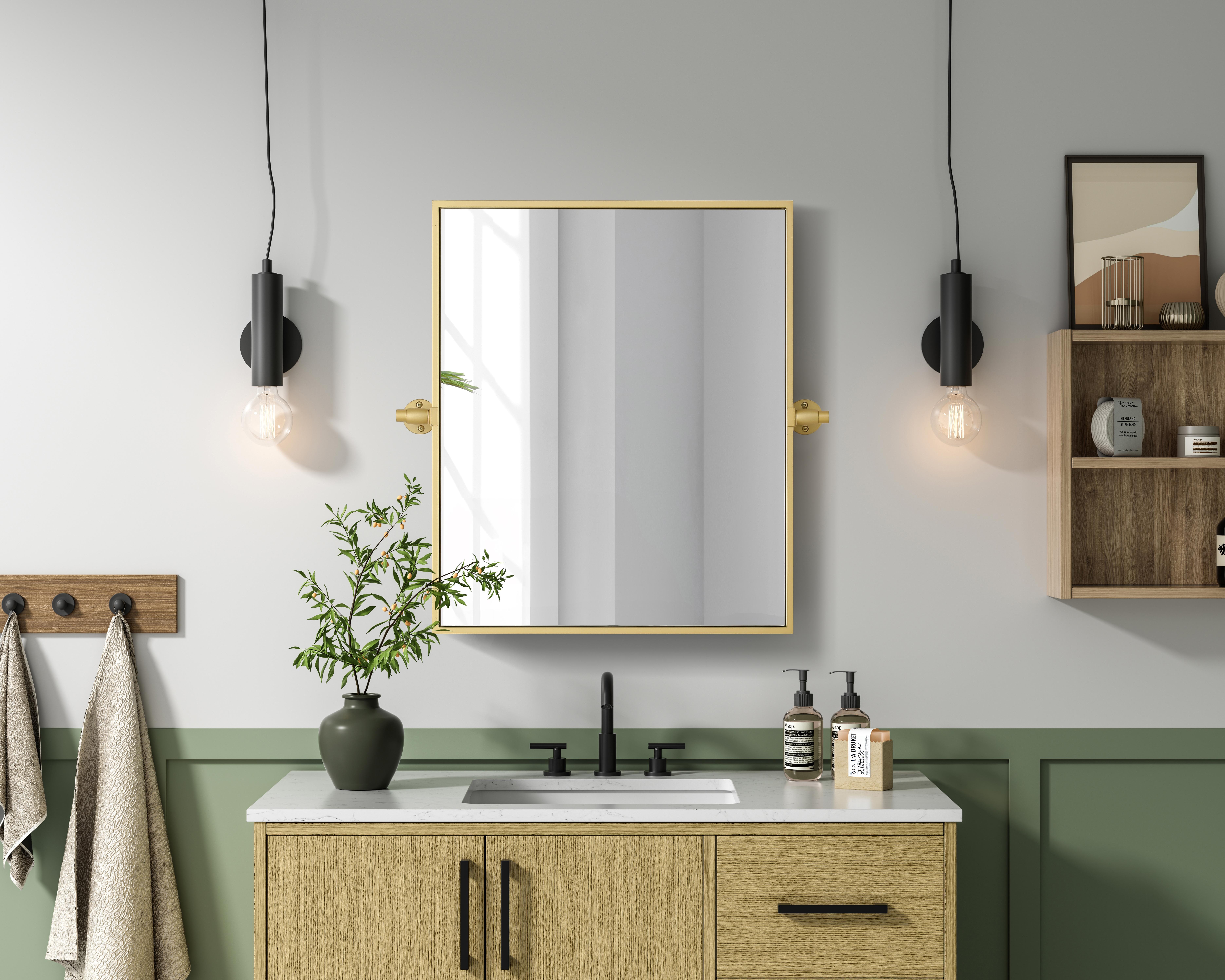Upgrade your space with a modern pivot mirror that offers both form and function. Featuring an adjustable 8-degree tilt, this mirror allows you to customize your viewing angle for convenience and style. The iron frame with MDF backing ensures durability, while the hand-painted finish—available in black, silver, and brass—adds a touch of sophistication. Designed for versatility, this rectangular mirror can be mounted vertically or horizontally, making it the perfect fit for bathrooms, bedrooms, offices, and more. Its slim metal frame provides a sleek, contemporary aesthetic that blends seamlessly into various design styles. With included mounting brackets and screws, installation is simple and secure, giving your space an instant refresh. Whether you're getting ready for the day or enhancing your home décor, this pivot mirror delivers both style and practicality. Collection: Amoura Rooms: Bathroom Finish: Brass Width: 20.00" Height: 24.00" Weight: 10.00 lb Extension from Wall: 3.00" Material: Iron and MDF Country of Origin: China Safety Rating: Damp Manufacturer Warranty: 1 year limited - alternate view