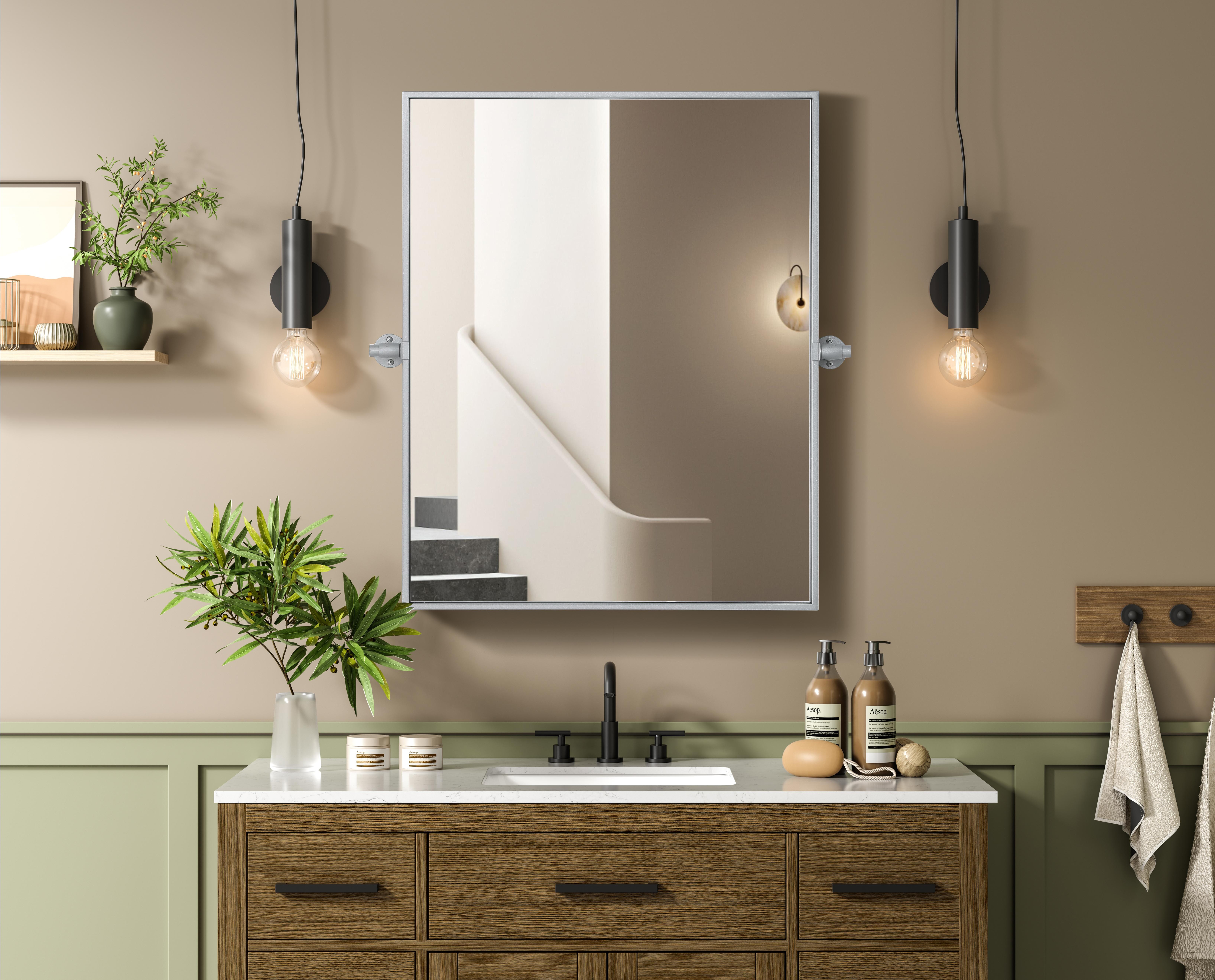 Upgrade your space with a modern pivot mirror that offers both form and function. Featuring an adjustable 8-degree tilt, this mirror allows you to customize your viewing angle for convenience and style. The iron frame with MDF backing ensures durability, while the hand-painted finish—available in black, silver, and brass—adds a touch of sophistication. Designed for versatility, this rectangular mirror can be mounted vertically or horizontally, making it the perfect fit for bathrooms, bedrooms, offices, and more. Its slim metal frame provides a sleek, contemporary aesthetic that blends seamlessly into various design styles. With included mounting brackets and screws, installation is simple and secure, giving your space an instant refresh. Whether you're getting ready for the day or enhancing your home décor, this pivot mirror delivers both style and practicality. Collection: Amoura Rooms: Bathroom Finish: Silver Width: 24.00" Height: 30.00" Weight: 16.00 lb Extension from Wall: 3.00" Material: Iron and MDF Country of Origin: China Safety Rating: Damp Manufacturer Warranty: 1 year limited - alternate view