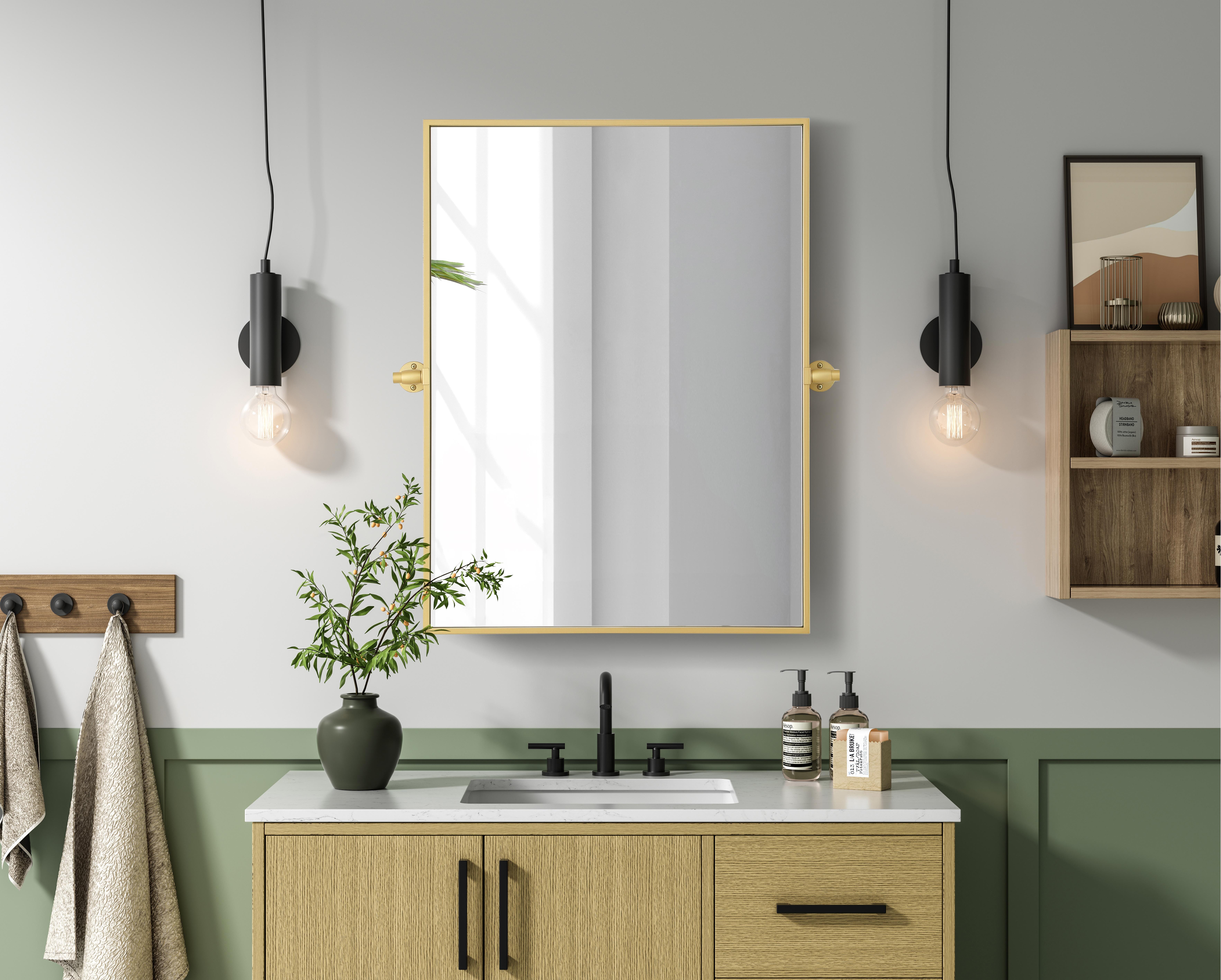 Upgrade your space with a modern pivot mirror that offers both form and function. Featuring an adjustable 8-degree tilt, this mirror allows you to customize your viewing angle for convenience and style. The iron frame with MDF backing ensures durability, while the hand-painted finish—available in black, silver, and brass—adds a touch of sophistication. Designed for versatility, this rectangular mirror can be mounted vertically or horizontally, making it the perfect fit for bathrooms, bedrooms, offices, and more. Its slim metal frame provides a sleek, contemporary aesthetic that blends seamlessly into various design styles. With included mounting brackets and screws, installation is simple and secure, giving your space an instant refresh. Whether you're getting ready for the day or enhancing your home décor, this pivot mirror delivers both style and practicality. Collection: Amoura Rooms: Bathroom Finish: Brass Width: 24.00" Height: 32.00" Weight: 17.00 lb Extension from Wall: 3.00" Material: Iron and MDF Country of Origin: China Safety Rating: Damp Manufacturer Warranty: 1 year limited - alternate view