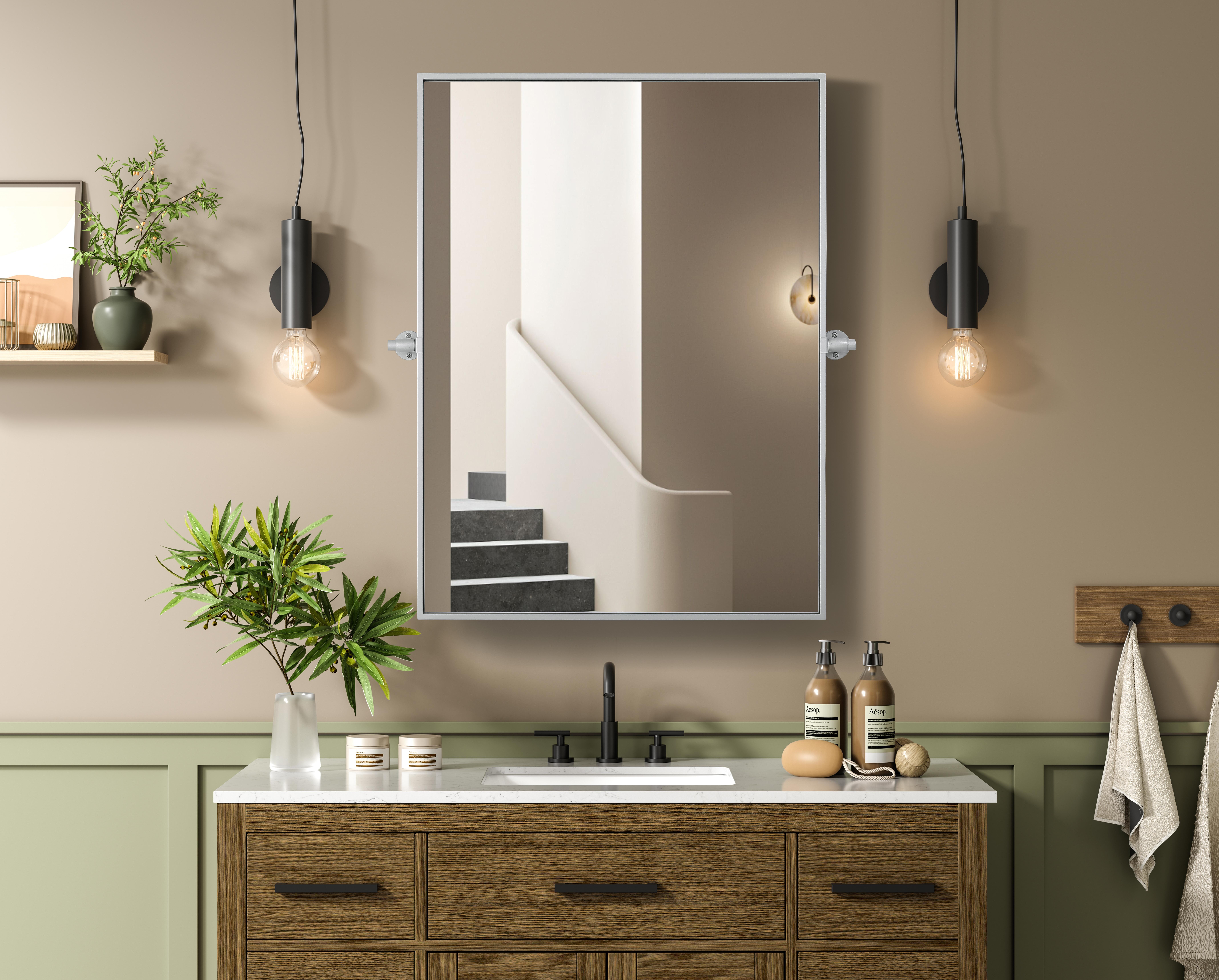 Upgrade your space with a modern pivot mirror that offers both form and function. Featuring an adjustable 8-degree tilt, this mirror allows you to customize your viewing angle for convenience and style. The iron frame with MDF backing ensures durability, while the hand-painted finish—available in black, silver, and brass—adds a touch of sophistication. Designed for versatility, this rectangular mirror can be mounted vertically or horizontally, making it the perfect fit for bathrooms, bedrooms, offices, and more. Its slim metal frame provides a sleek, contemporary aesthetic that blends seamlessly into various design styles. With included mounting brackets and screws, installation is simple and secure, giving your space an instant refresh. Whether you're getting ready for the day or enhancing your home décor, this pivot mirror delivers both style and practicality. Collection: Amoura Rooms: Bathroom Finish: Silver Width: 27.00" Height: 36.00" Weight: 22.00 lb Extension from Wall: 3.00" Material: Iron and MDF Country of Origin: China Safety Rating: Damp Manufacturer Warranty: 1 year limited - alternate view