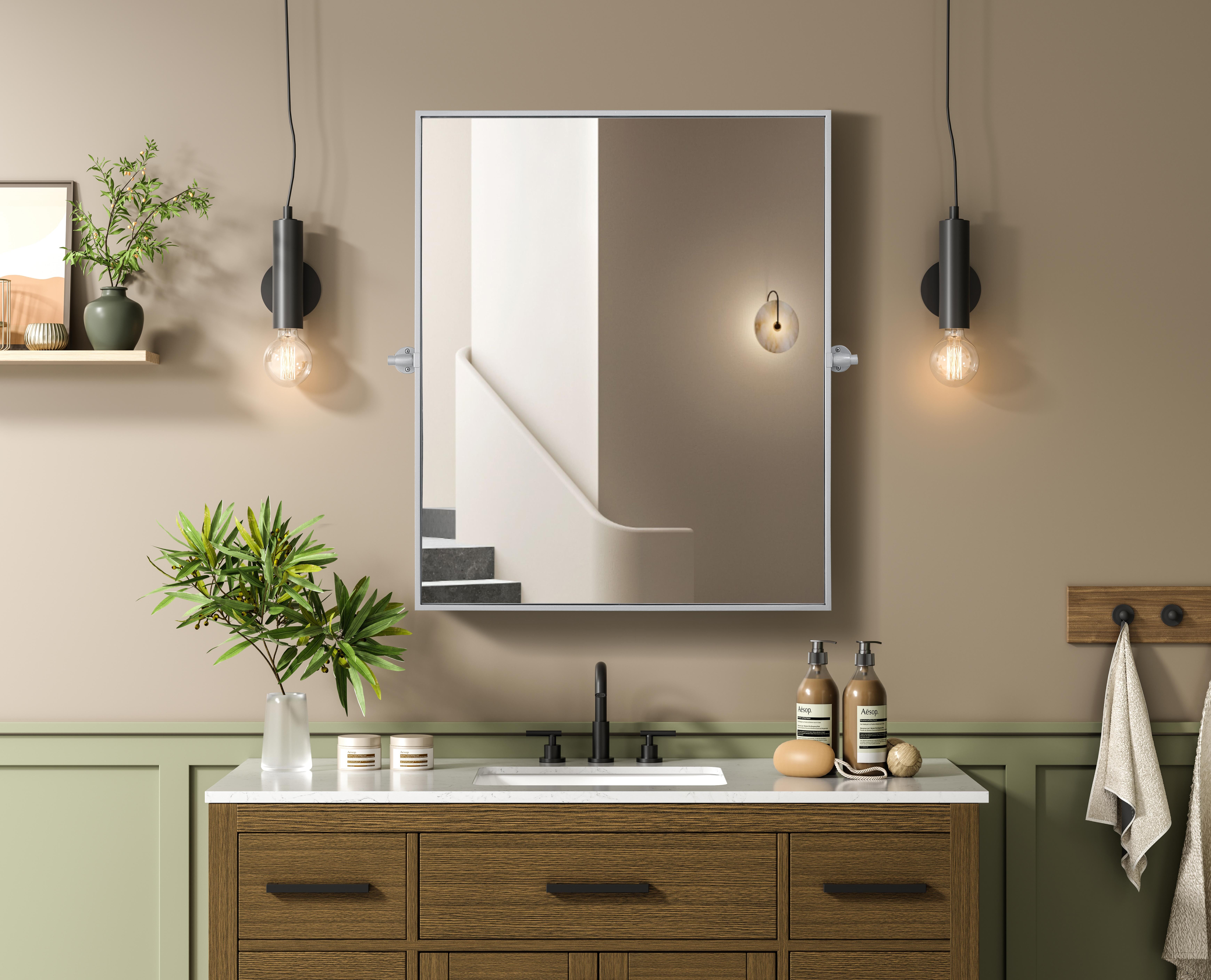 Upgrade your space with a modern pivot mirror that offers both form and function. Featuring an adjustable 8-degree tilt, this mirror allows you to customize your viewing angle for convenience and style. The iron frame with MDF backing ensures durability, while the hand-painted finish—available in black, silver, and brass—adds a touch of sophistication. Designed for versatility, this rectangular mirror can be mounted vertically or horizontally, making it the perfect fit for bathrooms, bedrooms, offices, and more. Its slim metal frame provides a sleek, contemporary aesthetic that blends seamlessly into various design styles. With included mounting brackets and screws, installation is simple and secure, giving your space an instant refresh. Whether you're getting ready for the day or enhancing your home décor, this pivot mirror delivers both style and practicality. Collection: Amoura Rooms: Bathroom Finish: Silver Width: 30.00" Height: 36.00" Weight: 24.00 lb Extension from Wall: 3.00" Material: Iron and MDF Country of Origin: China Safety Rating: Damp Manufacturer Warranty: 1 year limited - alternate view